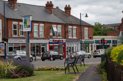 A view of Sandiacre village centre showing the village sign with the WW1 & WW2 memorial benches